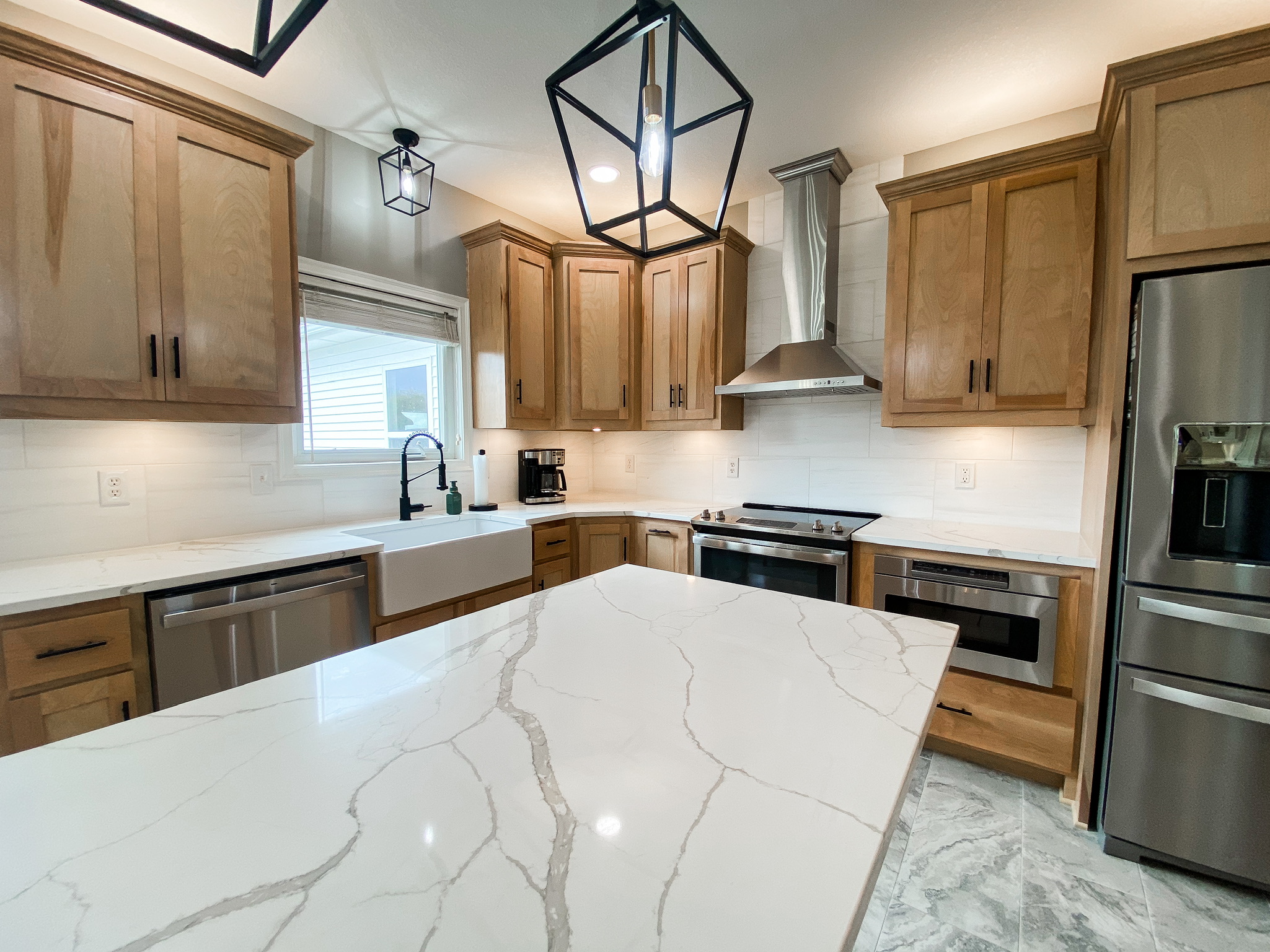 Modern kitchen with marble island and wooden cabinets