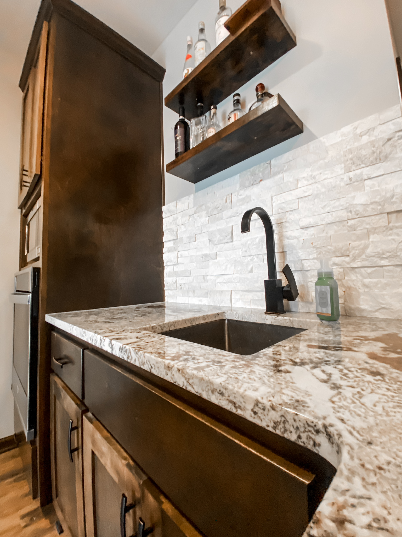 Granite countertop kitchen sink with stone backsplash